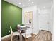 Stylish dining area featuring a modern table, chairs, and an eye-catching green accent wall at 17125 W 91St Ln, Arvada, CO 80007