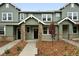 Inviting townhouse with stone accents, covered porch, manicured landscaping, and modern design at 17125 W 91St Ln, Arvada, CO 80007