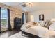 A cozy bedroom features a stone accent wall and plush bedding for a relaxing retreat at 15280 Bannock St, Broomfield, CO 80023