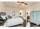 A bedroom features an iron bed frame, wood floors, a ceiling fan, and access to the bathroom at 15280 Bannock St, Broomfield, CO 80023