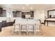 Open kitchen with breakfast bar, dark cabinetry, stainless steel appliances, and stone tile flooring at 15280 Bannock St, Broomfield, CO 80023