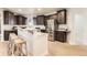 Gourmet kitchen featuring dark cabinetry, stainless steel appliances, granite countertops and bar seating at 15280 Bannock St, Broomfield, CO 80023
