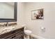 Powder room features rustic vanity, granite countertop, framed mirror, and modern fixtures at 15280 Bannock St, Broomfield, CO 80023