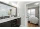 Elegant bathroom with double sinks, mosaic mirror border, and a view into the main bedroom at 1933 Grove St, Denver, CO 80204