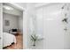 Modern bathroom featuring a glass-enclosed shower, white tiles, and a peek into the main bedroom at 1933 Grove St, Denver, CO 80204