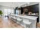 Modern kitchen with a large island, stainless steel appliances, dark cabinets and stylish bar stool seating at 1933 Grove St, Denver, CO 80204