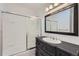 Bathroom with dark wood vanity, shower over tub, and bright lighting at 3353 S Glencoe St, Denver, CO 80222