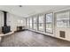 Sun room with a wood-burning stove, wood paneling, and floor-to-ceiling windows at 3353 S Glencoe St, Denver, CO 80222