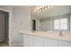 Bright bathroom featuring double sinks, a large mirror with vanity lighting, and a glass-enclosed shower at 5755 S Zante Cir, Aurora, CO 80015
