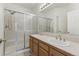 Bathroom with double sinks, a large vanity mirror, and shower with sliding glass doors at 12879 E Dickensen Pl, Aurora, CO 80014