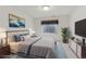 Staged bedroom with plush queen bed, modern decor, and a window view at 12879 E Dickensen Pl, Aurora, CO 80014