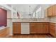 Well-lit kitchen features wood cabinets, tile countertops and backsplash, and stainless-steel appliances at 12879 E Dickensen Pl, Aurora, CO 80014