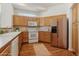 Bright kitchen featuring white appliances, oak cabinets, a tile backsplash, and hardwood floors at 12879 E Dickensen Pl, Aurora, CO 80014