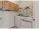 Functional laundry room featuring a modern washer and dryer set, and ample cabinet storage at 12879 E Dickensen Pl, Aurora, CO 80014