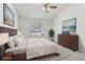 Stylishly staged bedroom features a large window, ceiling fan, and well-coordinated decor at 12879 E Dickensen Pl, Aurora, CO 80014
