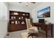 Stylishly designed home office features a wooden bookshelf, desk, and comfortable office chair at 12879 E Dickensen Pl, Aurora, CO 80014
