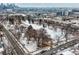 An aerial view showing the neighborhood near a snow covered park and the city skyline in the background at 2729 W 28Th Ave # 401, Denver, CO 80211