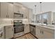 This modern kitchen offers stainless steel appliances, stone countertops, a subway tile backsplash, and wood grain cabinets at 2729 W 28Th Ave # 401, Denver, CO 80211