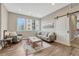 A light and airy living room features modern furniture, wooden floors, and a sliding barn door for privacy at 2729 W 28Th Ave # 401, Denver, CO 80211