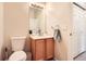 Compact half bathroom featuring a modern toilet, sink, and vanity with a convenient towel ring at 5255 Memphis St # 311, Denver, CO 80239
