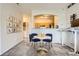 Inviting dining area with a round table, blue chairs, and a view into the kitchen and laundry area at 5255 Memphis St # 311, Denver, CO 80239