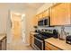 Modern kitchen equipped with stainless steel appliances and ample storage space, adjacent to a hallway at 5255 Memphis St # 311, Denver, CO 80239