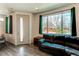 Bright living room with a large window, wood floors, and a comfortable leather sofa at 1075 Spartan Ave, Berthoud, CO 80513