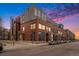 Modern building with red brick and large windows, complemented by a colorful sunset at 2955 Inca St # 2L, Denver, CO 80202