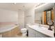 Well-lit bathroom with a soaking tub, vanity, and tiled flooring at 31819 Rocky Village Dr # 208, Evergreen, CO 80439