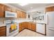Clean kitchen featuring oak cabinets, white appliances, and a modern sink under a window at 31819 Rocky Village Dr # 208, Evergreen, CO 80439