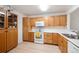 Well-maintained kitchen with wood cabinets, white appliances, and bright countertops in a functional layout at 31819 Rocky Village Dr # 208, Evergreen, CO 80439