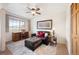 Bright living room with a leather sofa, ottoman, and a work desk in front of a window offering scenic views at 31819 Rocky Village Dr # 208, Evergreen, CO 80439
