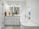 Elegant bathroom features double sinks, a bathtub and natural light from a window at 1333 N Lafayette St, Denver, CO 80218