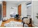 Bright bedroom features exposed brick, two chairs and hardwood floors with a view into an additional bedroom at 1333 N Lafayette St, Denver, CO 80218