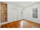 Bright bedroom with exposed brick accent wall, hardwood floors, and closet at 1333 N Lafayette St, Denver, CO 80218
