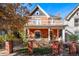 Charming red brick two-story home with white trim, inviting porch, and beautiful architectural details at 1333 N Lafayette St, Denver, CO 80218
