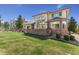 Charming backyard with a spacious deck, lush green lawn, mature trees, and beautiful architectural home design at 7132 S Tempe Ct, Aurora, CO 80016