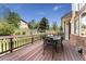 Beautiful backyard deck features table seating, a wooden fence, a brick wall, and bright sunlight at 7132 S Tempe Ct, Aurora, CO 80016