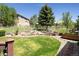 Lush backyard featuring a well-manicured lawn, mature trees, and garden beds, creating a peaceful outdoor oasis at 7132 S Tempe Ct, Aurora, CO 80016