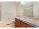 Bright bathroom featuring wooden cabinets, a tiled countertop, and a shower with glass doors at 7132 S Tempe Ct, Aurora, CO 80016