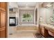 Luxurious bathroom featuring a soaking tub next to a fireplace and garden views at 7132 S Tempe Ct, Aurora, CO 80016