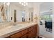 Bathroom with double sinks, light-colored countertops, and a clear view into an adjacent bedroom at 7132 S Tempe Ct, Aurora, CO 80016
