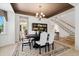 Elegant dining room with a chandelier, a formal dining table, and large window view at 7132 S Tempe Ct, Aurora, CO 80016