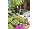 Landscaped front yard with colorful flowers, green bushes, and a brick home entrance at 7132 S Tempe Ct, Aurora, CO 80016