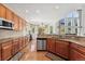 Kitchen with stone countertops, wood cabinets, stainless steel dishwasher, and hardwood floors at 7132 S Tempe Ct, Aurora, CO 80016
