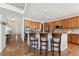 A spacious kitchen features wood cabinets, stone countertops, and a breakfast bar with seating for three at 7132 S Tempe Ct, Aurora, CO 80016