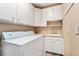 Efficient laundry room featuring a washer, dryer, and ample storage cabinets at 7132 S Tempe Ct, Aurora, CO 80016