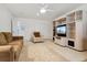Cozy living room with a ceiling fan, decorative carpet, and built-in entertainment center at 7132 S Tempe Ct, Aurora, CO 80016