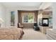A serene main bedroom features a fireplace, balcony, and garden views at 7132 S Tempe Ct, Aurora, CO 80016