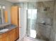 Modern bathroom featuring a glass shower with decorative tile and wood-finished vanity with granite countertop at 7753 W Plymouth S Pl, Littleton, CO 80128